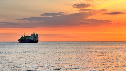 beautiful sunset with ship to the horizon. golden hour at sea