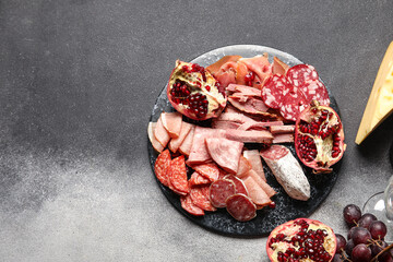 Slate plate with assortment of tasty deli on grunge background