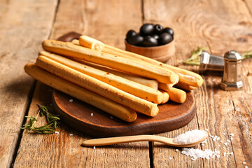 Board with tasty Italian Grissini on wooden background