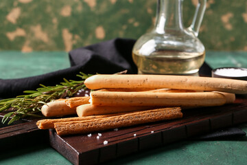 Wooden board with tasty Italian Grissini on table