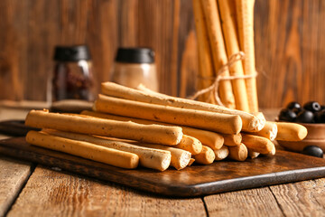 Board with tasty Italian Grissini on wooden background
