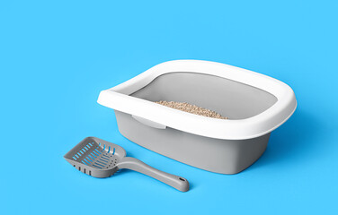 Litter box for cat and scoop on blue background