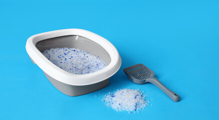 Litter box for cat and scoop on blue background