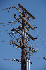 Electricity distribution pylon and power lines under blue sky