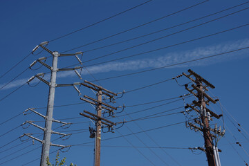 Electricity distribution pylons and power lines under blue sky