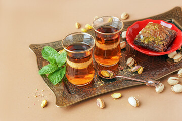 Tray with glasses of Turkish tea on beige background