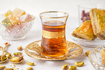 Glass of tea and Turkish delight on white background