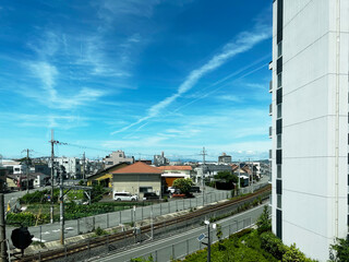 飛行機雲のある鉄道と街並み