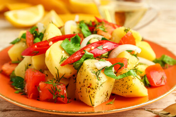 Plate of tasty Potato Salad with vegetables on table, closeup