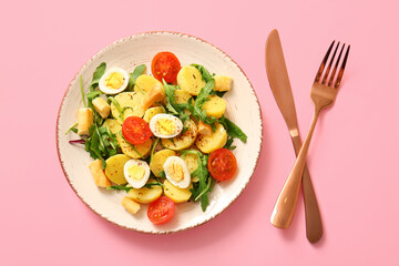 Plate of tasty potato salad with eggs and tomatoes on pink background, top view