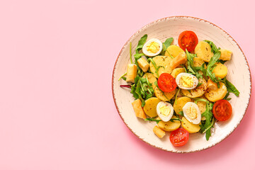 Plate of tasty potato salad with eggs and tomatoes on pink background, top view