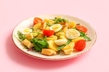 Plate of tasty potato salad with eggs and tomatoes on pink background
