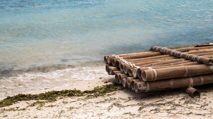 an old bamboo raft on the shore of a tropical island, abandoned