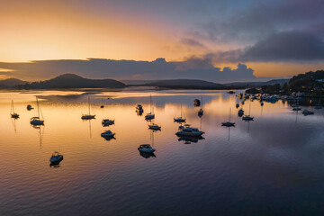 Soft and hazy aerial sunrise waterscape with boats
