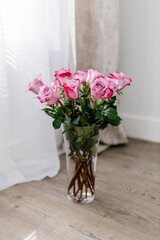 Bouquet of pink roses in light room. Flowers close up. Deep pink petal close up. Space for text