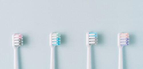 Four multi-colored nozzles from an electric toothbrush on a blue background.