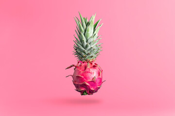 Creative concept of food art. Dragon fruit with pineapple tops on a pink background. Exotic fruit concept.
