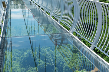Suspended glass bridge over a cliff. Extreme tourism.