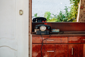 old analog disk phone on a wooden chest of drawers in retro style