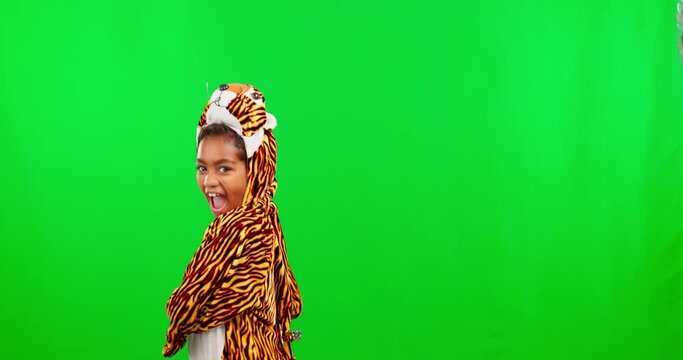 Costume, dance and child in a studio with green screen in a tiger outfit doing a scratching movement. Happy, smile and portrait of girl kid model in an animal cosplay outfit by chroma key background.