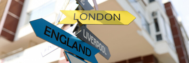 Tourist pointers of different cities and countries on pillar closeup