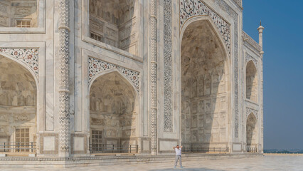 Unique Taj Mahal. Symmetrical mausoleum with arches, spires.On the white marble walls there are...