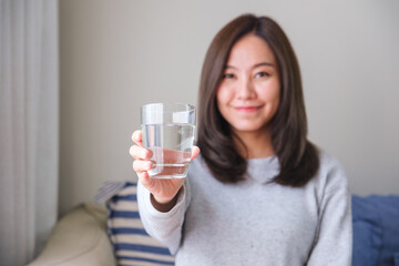 Portrait image of a young woman holding and drinking water
