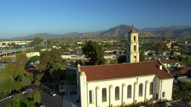Aerial Shot Of Cross Symbol On St. Mary Magdalen Chapel In City Against Clear Sky, Drone Flying Backwards During Sunny Day - Camarillo, California