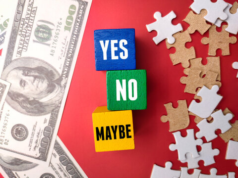 Banknotes and puzzle with the word YES NO MAYBE on red background