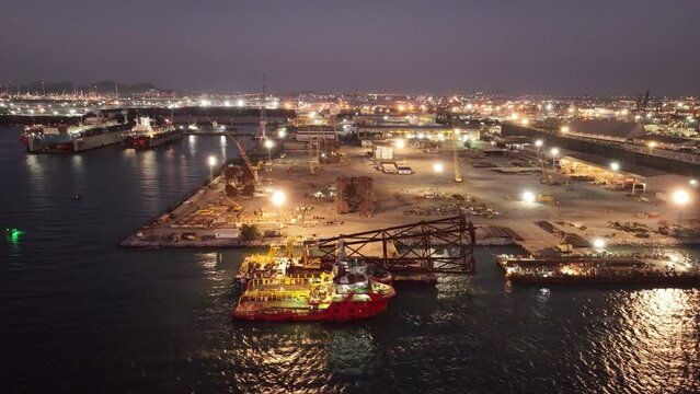 Big Drilling rid on Smart Barge. Construction port at harbor cranes at sunset. Shipyard at sunset. Making big drilling rig contruction on port.