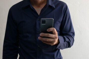 Man playing on mobile phone in house typing text messages chatting online