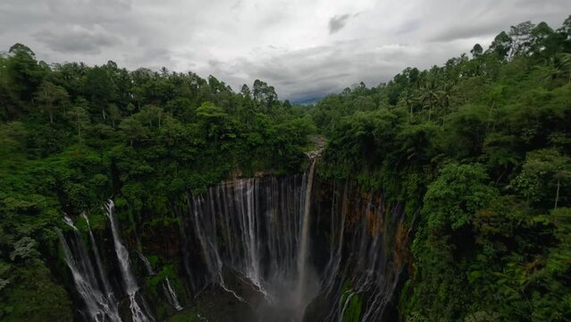 Dive tropical island waterfall speed water fall stream stones rainforest mountain valley aerial view. FPV sport drone extreme shot exotic jungle cascade fern greenery woodland cliff creek pool scenery