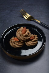 homemade halal quqi cookies with peanut, matcha, earl grey tea, almond green tea and icing sugar in round shape on black and gold luxury background handmade fresh bakery pastry halal menu