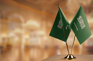 Small flags of the Saudi Arabia on an abstract blurry background