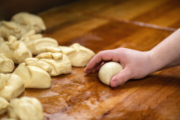 Fototapeta na wymiar Chefs Hand Preparing Round Pieces of Dough