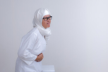 Hungry moslem girl pressing her stomach waiting for fasting break time, during ramadan month