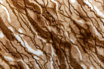 The surface of the plaid is made of fur of an animal pattern. Comfort and decor in the house. Close-up. Top view.