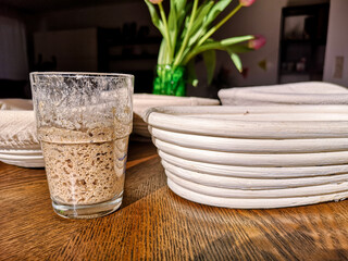 Glass with rye sourdough against the background of a basket of rottan