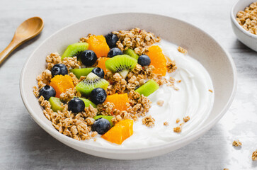 Yogurt with Granola, Kiwi, Blueberries, and Orange in a Bowl, Healthy Snack or Breakfast