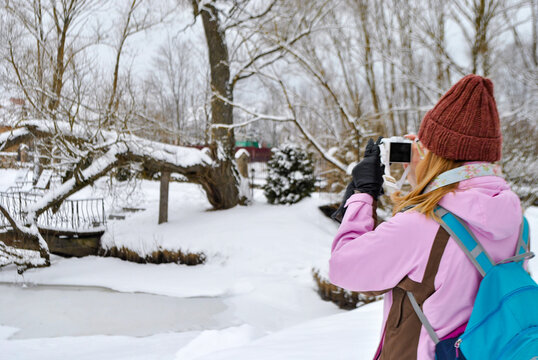 View of a woman taking pictures of winter nature