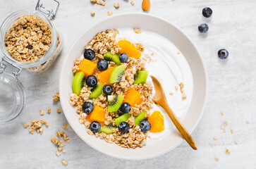 Yogurt with Granola, Kiwi, Blueberries, and Orange in a Bowl, Healthy Snack or Breakfast