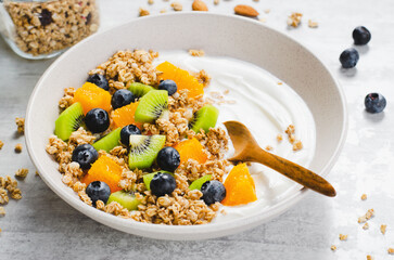 Yogurt with Granola, Kiwi, Blueberries, and Orange in a Bowl, Healthy Snack or Breakfast