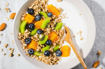 Yogurt with Granola, Kiwi, Blueberries, and Orange in a Bowl, Healthy Snack or Breakfast