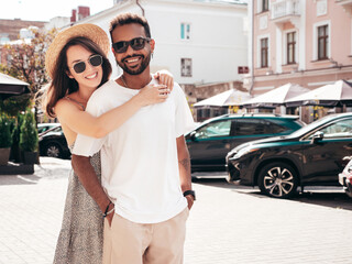 Smiling beautiful woman and her handsome boyfriend. Woman in casual summer clothes. Happy cheerful family. Female having fun. Sexy couple posing in the street at sunny day. In hat and sunglasses