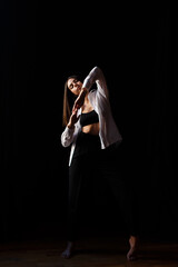 brunette actress dances barefoot in the rehearsal hall of the theater