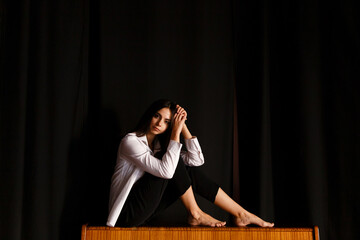 young actress sits at the piano in the rehearsal hall of the theater