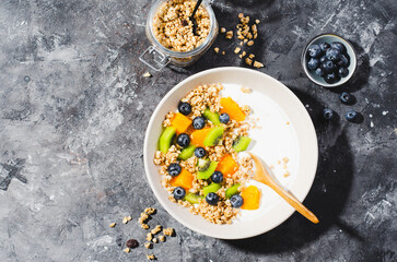 Yogurt with Granola, Kiwi, Blueberries, and Orange in a Bowl, Healthy Snack or Breakfast