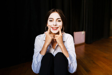 happy actress in a costume with white make-up in the rehearsal theater