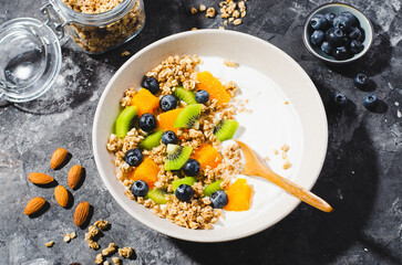 Yogurt with Granola, Kiwi, Blueberries, and Orange in a Bowl, Healthy Snack or Breakfast