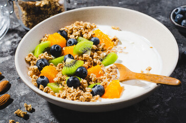 Yogurt with Granola, Kiwi, Blueberries, and Orange in a Bowl, Healthy Snack or Breakfast